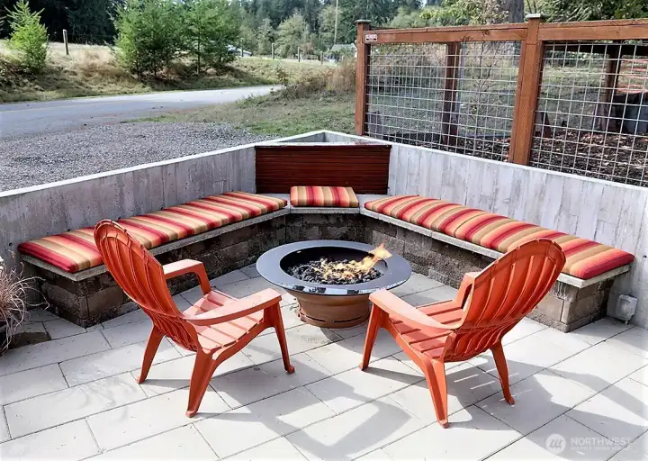 Outdoor bench seating area with forged fire pit hard piped to propane.