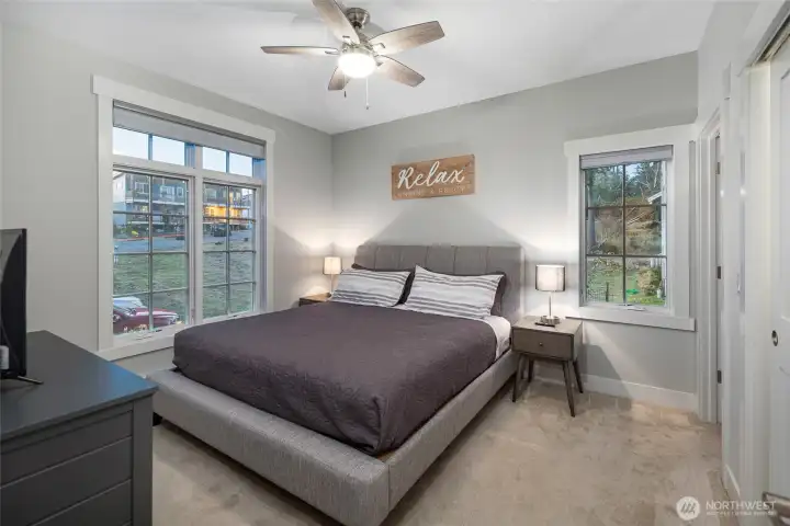 Bright and peaceful primary bedroom featuring large windows that frame the surrounding island landscape and bring in abundant natural light.