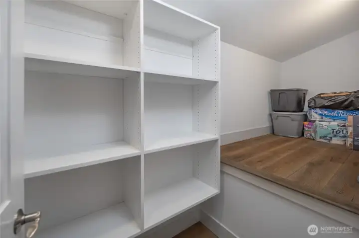 Spacious pantry with built-in shelving and countertop workspace provides excellent storage and organization for kitchen essentials.
