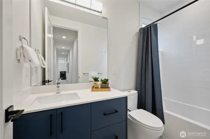 Full size guest bath with good-vanity, soaking tub and completely tiled shower surround.