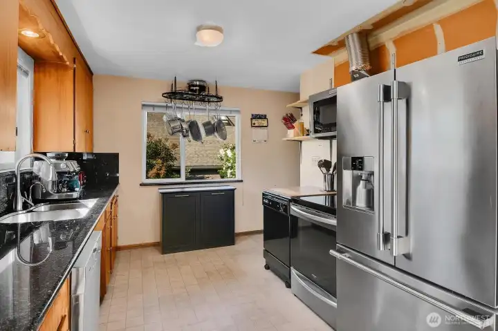 Updated stainless appliances and granite counters add a modern touch to the original wood cabinetry.