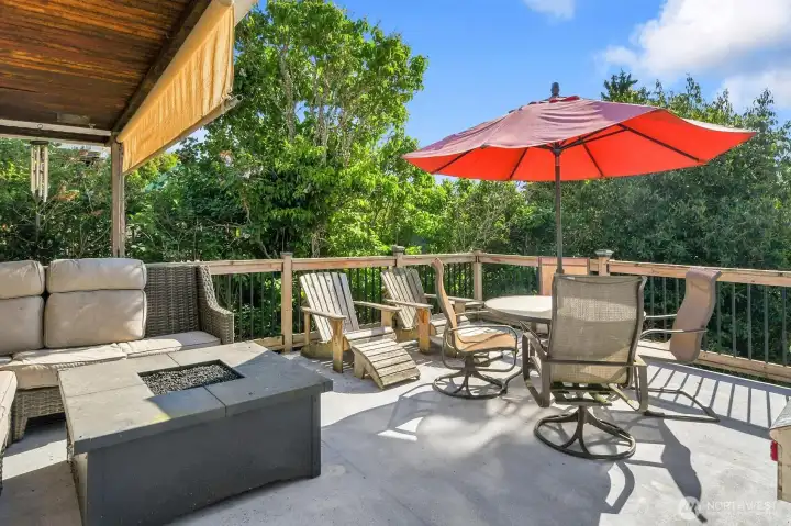 This deck is made for entertaining!  There is plenty of sitting room with a view of the mature fruit trees in the back yard, and peak views of the water beyond.  The yard is very private and is fully fenced for your four legged friends enjoyment.