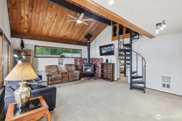 Family room with exposed beam and vaulted wood plank ceilings.