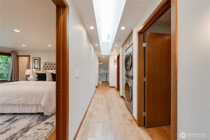 The upstairs hallway showcases the skylight as the work of art. You will love this. The upstairs laundry center is conveniently located between the two secondary bedrooms on this floor and across the hall from the primary. The upstairs hallway showcases the skylight as the work of art. You will love this. The upstairs laundry center is conveniently located between the two secondary bedrooms on this floor and across the hall from the primary.