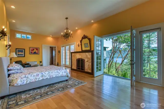 Primary Bedroom with centerpiece fireplace and French doors to water/mountain views and possible future deck