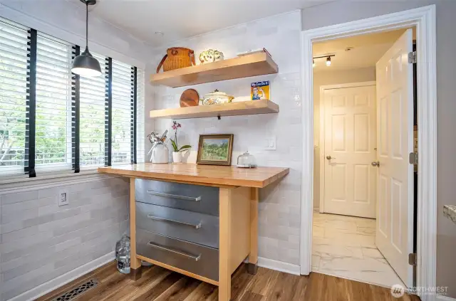 An additional workspace or cozy dining nook adds versatility to the layout. The nearby doorway leads to the utility room, a convenient 3/4 bath, garage and exterior access to the patio—perfect for indoor-outdoor living.