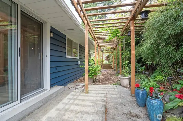 Step through the sliding door off the dining area into a picturesque arbor-covered walkway, offering the perfect setting for your own tranquil garden retreat.