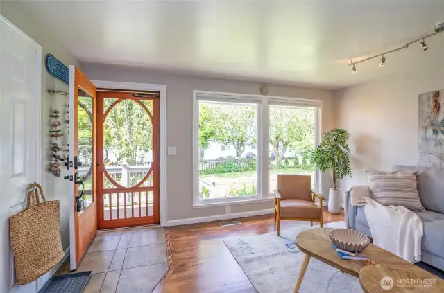 Stepping inside feels like a breath of fresh air—floor-to-ceiling windows fill the living space with natural light, while the beautifully refinished hardwood floors make a lasting impression.