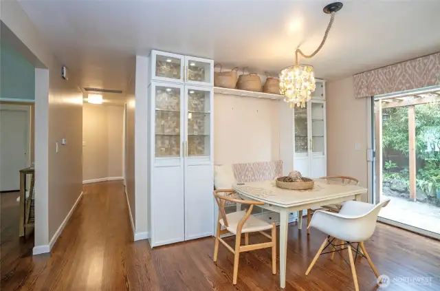 The dining area features built-in seating and cabinetry, providing comfort and extra space to showcase your favorite pieces. A convenient hallway leads to the bedrooms and the main full bath.