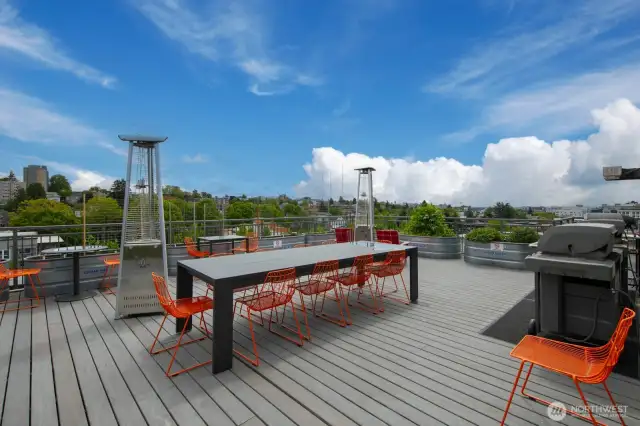 Expansive rooftop deck with shared grills, heaters, and seating.