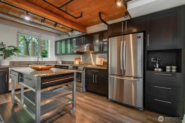 Thoughtfully designed kitchen with granite counters, gas range, and movable island for added flexibility.