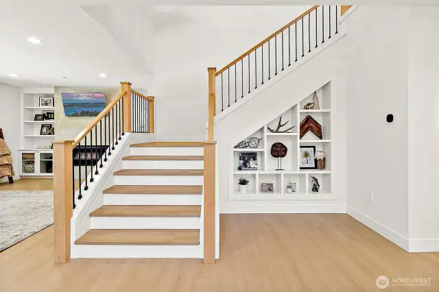 Wide staircase with modern rails and custom bookshelf display.