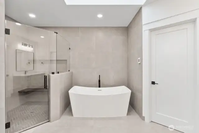 Primary bath with free standing tub, oversized curbless shower with framless glass.