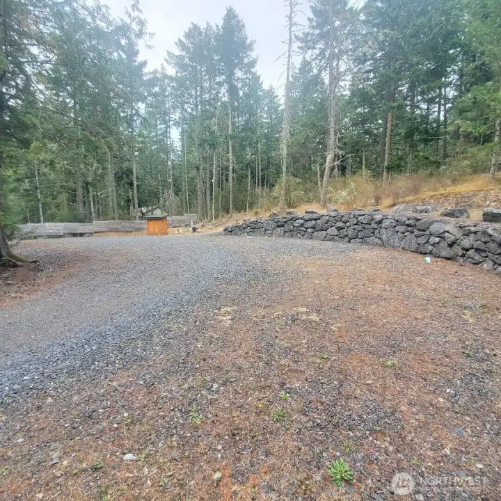 View of lot from top of private driveway. Insulated pump house in distance. 3 separate drop ports for septic hookup. Three 50 AMP power receptacles.