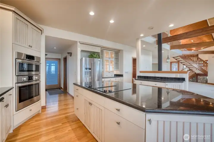 THE ISLAND COOK TOP IS ALMOST INVISIBLE AGAINST THE BLACK GRANITE COUNTERS!