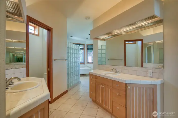 THE LARGE BATHROOM HAS HIS AND HERS TILED SINKS WITH RECESSED LIGHTING! THE EASY CARE TILED FLOORS MAKE THE ROOM LOOK EVEN LARGER! BEHIND THE GLASSED WALL IS THE SHOWER AND THEN SOAKING TUB!