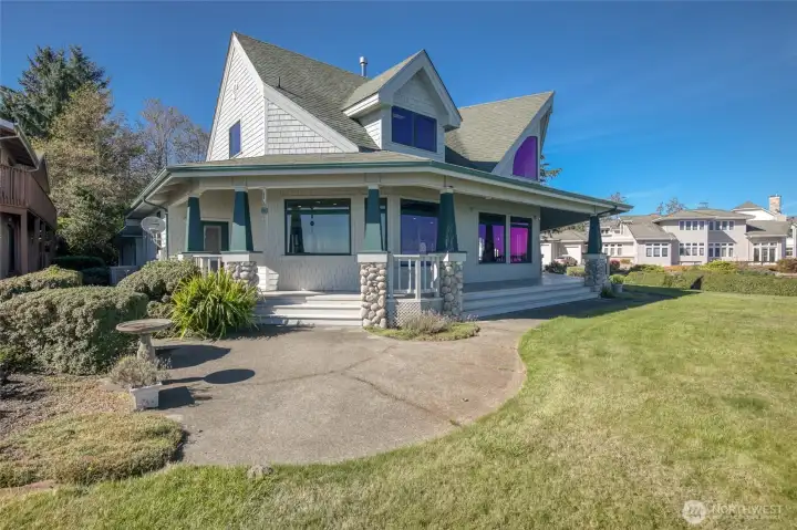 VIEW TO THE NORTH OF THE HOME HIGHLIGHTING THE WRAP AROUND VERANDA AND LANDSCAPING!