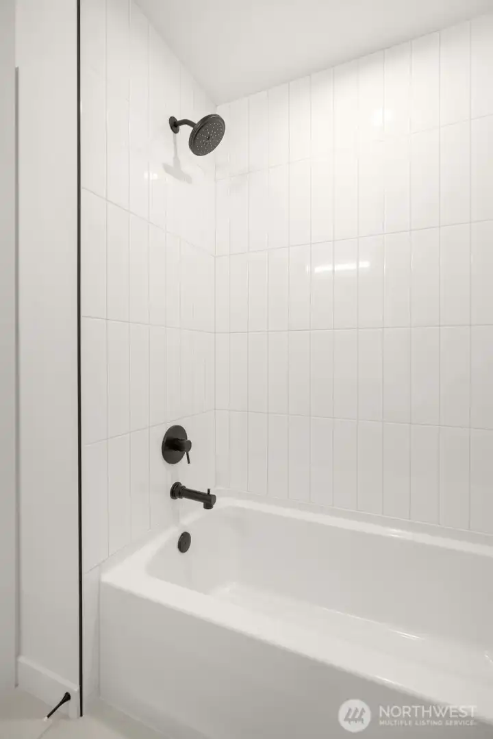 Full height tile tub/shower surround in first level bathroom.  Photos are staged model of similar floorplan. Color scheme and layout will differ.