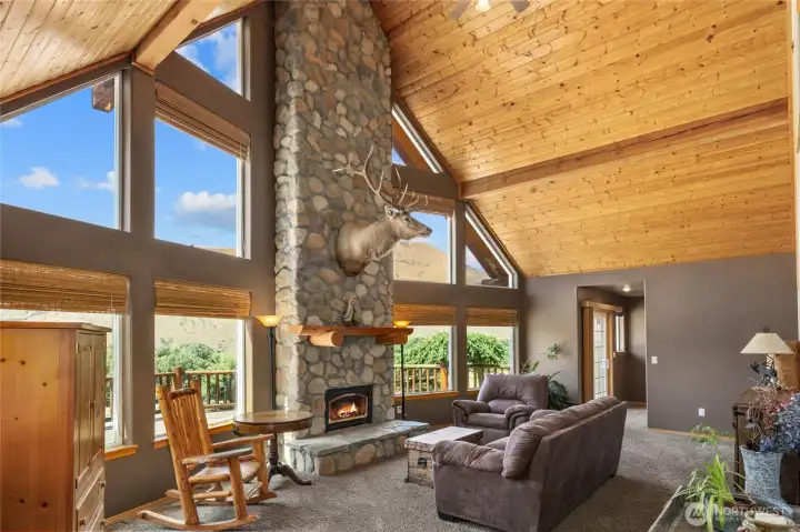 The great room has a rock fireplace with gas insert.  Love the wood lined ceiling and natural light that comes in the picture windows!