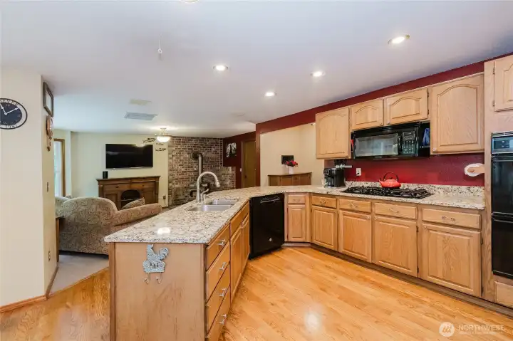 Open kitchen design with Corian countertops, gas stove + double oven.