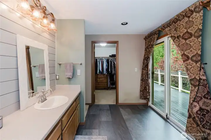 Primary bathroom with walk-in closet and additional sliding door to outside deck.