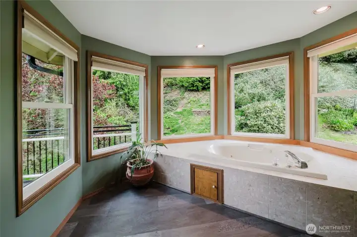 Luxurious jetted tub in primary suite with separate adjoining shower.