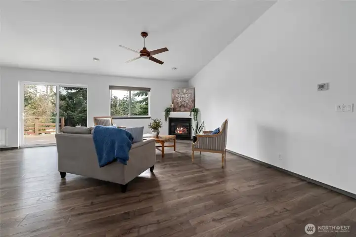 Living room with cozy gas fire place and sliding glass door to deck.