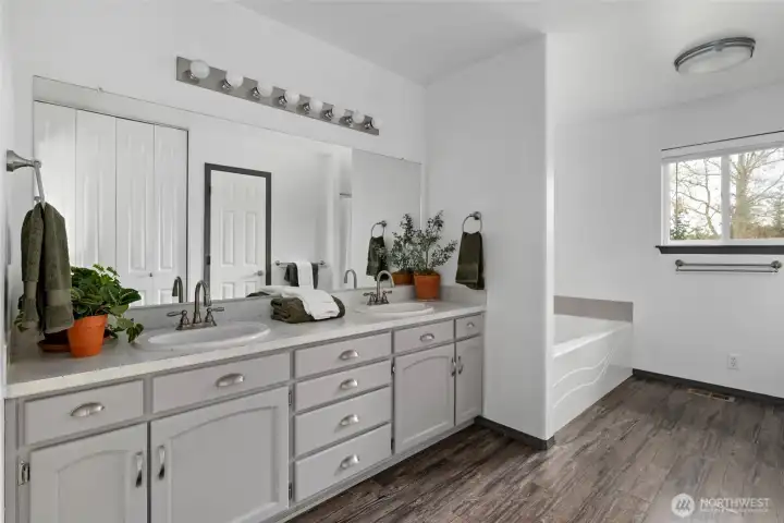 Double sink vanity and soaking tub in the primary bathroom.