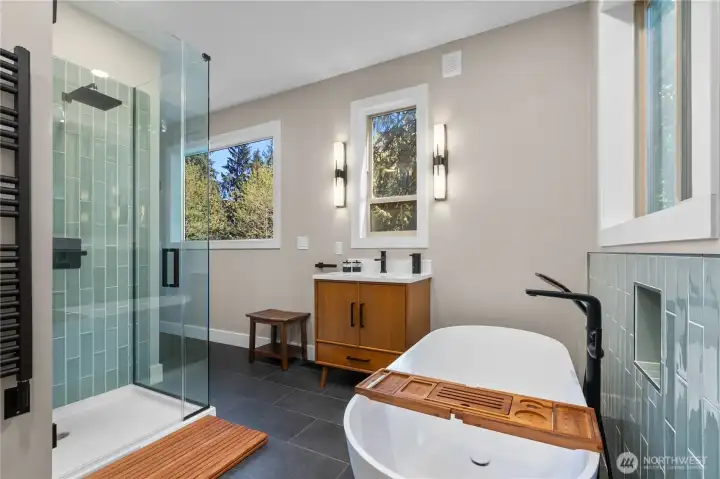 The spa-like en suite features custom tilework, a glass shower and beautiful freestanding tub.