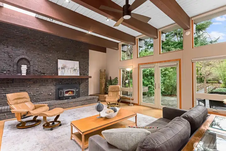 A dramatic brick wall and functioning wood stove anchor the less formal areas of the great room. The built-in cabinet in the corner makes a perfect TV stand for this room to serve as the media room.