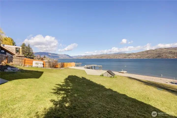 Lakeside living with a lawn that provides space for games, gatherings or possibly even a pool.