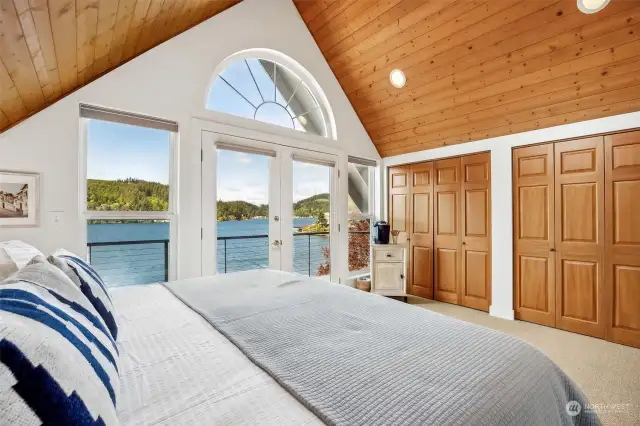 Primary suite offers cathedral ceilings, double closets, French doors to a private deck with an AMAZING view of the lake.