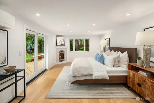 Primary bedroom with fireplace and French doors that lead to private deck.