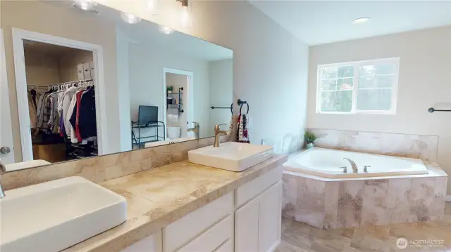 Primary bedroom 5-piece ensuite with double vanity, soaking tub, separate door to privy & shower and large walk-in closet