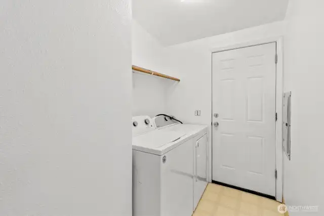 Laundry room off of the kitchen with door leading to the side yard