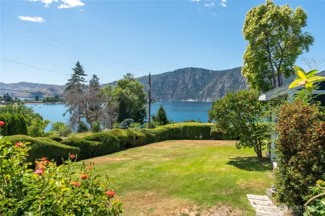 Lush, professionally landscaped yard with vibrant seasonal blooms, mature trees, and manicured lawn — a serene outdoor retreat perfect for entertaining, play, or peaceful relaxation.