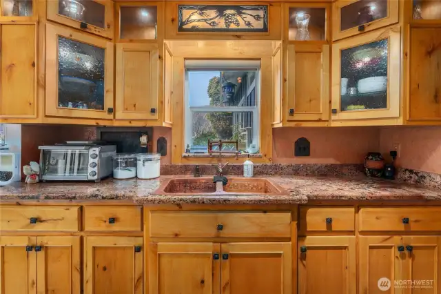 Enjoy the warmth of handcrafted copper sinks paired with custom-designed cabinetry, bringing character and quality to this thoughtfully curated kitchen.