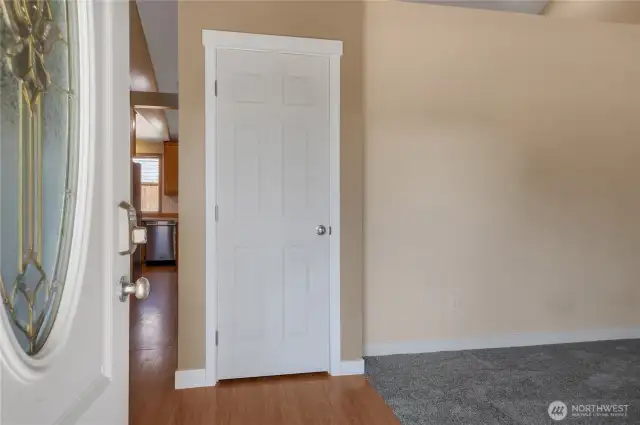 Entry into formal living space and hallway to kitchen and family room