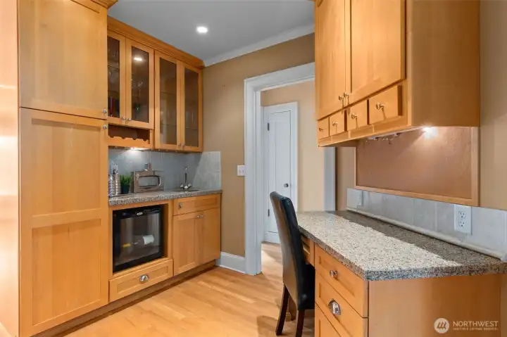 The wet bar is complete with a wine refrigerator and additional stainless steel sink. The built-in desk with the granite countertop is practical and inviting for day-to-day living.