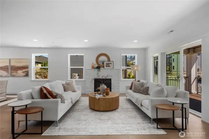 Great Room: Spacious great room with a modern tile-surround fireplace and large windows filling the room with light. The open floor plan connects to the kitchen and dining spaces, ideal for gatherings or relaxing evenings.  Staged photos are of the model home of the same floorplan within the Foxmoore community and are for visualization purposes only. Colors, finishes, and layout can and will vary.