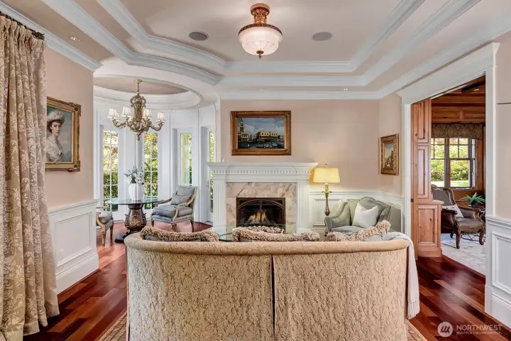 Formal living room. Attention to detail throughout. One of 7 gas fireplaces in the home. The turret section is perfect for a baby grand piano.
