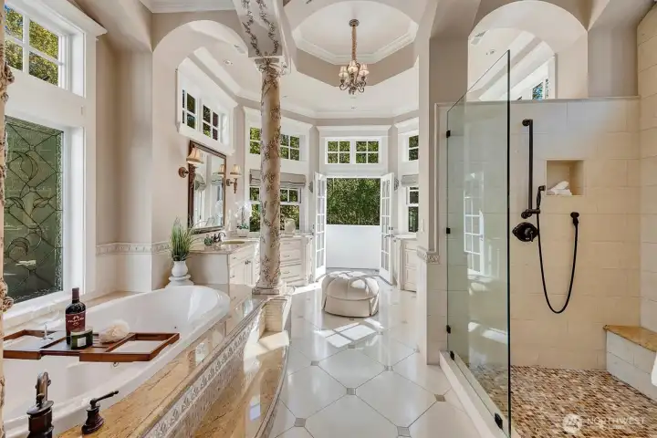 Sumptuous primary bath complete with jetted soaking tub, heated flooring, and Juliet balcony