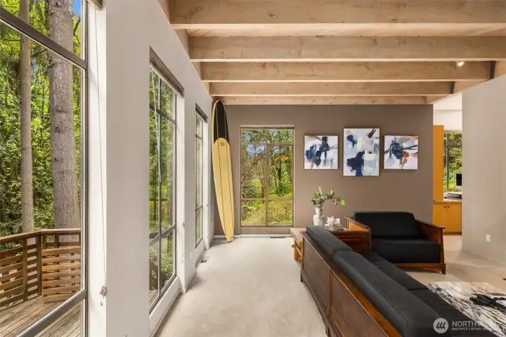 Floor-to-ceiling windows fill the main living area with natural light, creating a seamless flow between indoors and outdoors.