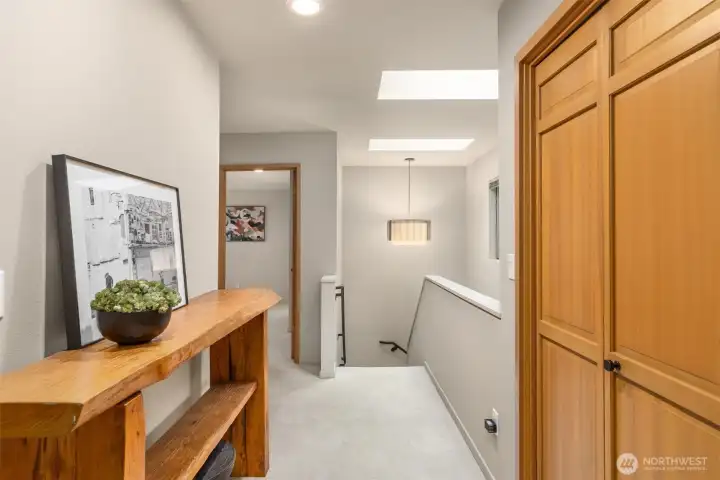 Skylights flood the upper level and stairwell with natural light, creating an airy, open feel throughout.