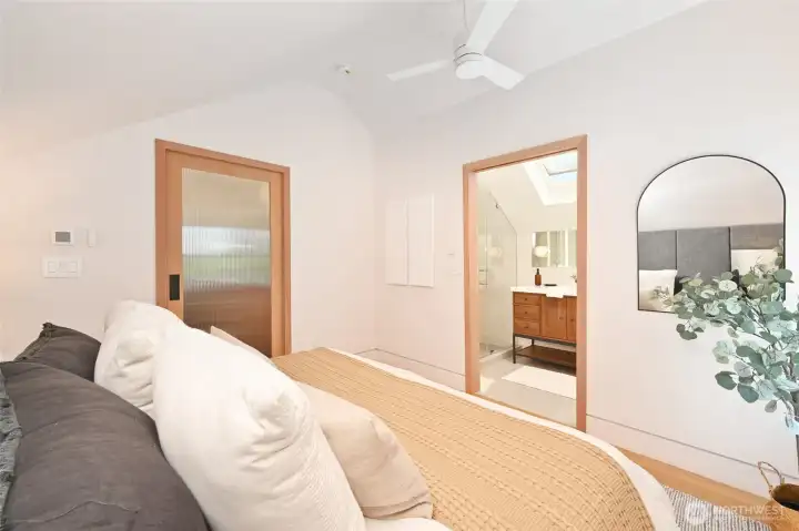 Engineered hardwood flooring, vaulted ceiling fan, pocket doors, and skylights in primary suite. Engineered hardwood flooring, vaulted ceiling fan, pocket doors, and skylights in primary suite.
