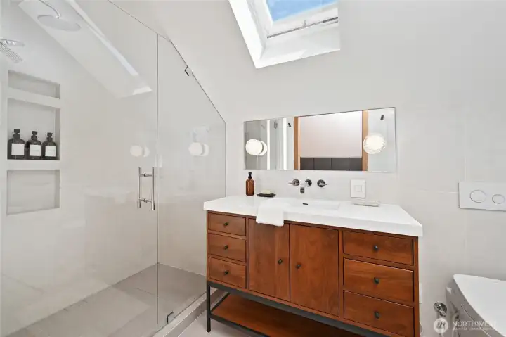 Primary suite 3/4 bathroom features heated floor, highend fixtures, accent lighting, automated skylight, and vacuum suction laundry chute. Primary suite 3/4 bathroom features heated floor, highend fixtures, accent lighting, automated skylight, and vacuum suction laundry chute.