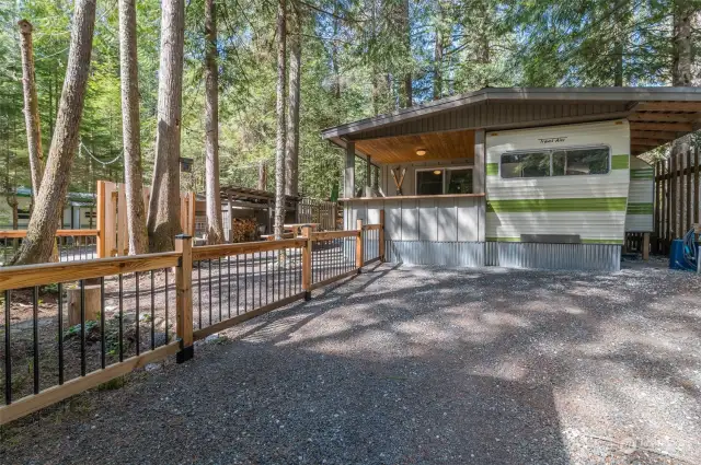 Tons of parking space, large fenced yard area, plenty of trees to hang your hammock or have a fire! Cozy up on the covered front porch with built in BBQ and mini fridge. Well maintained and thought out lot design. Fully fenced area, darling additional sleeping cabin and so much more! No detail spared!