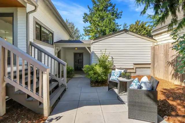 Charming fully fenced backyard with covered deck and paved patio