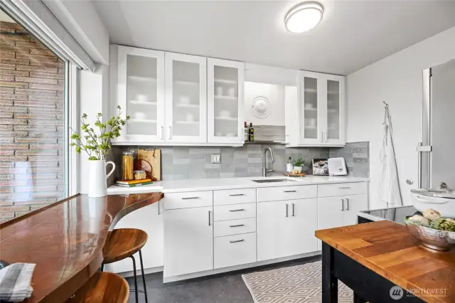 Kitchen features a copper top breakfast bar and is is updated with new wood cabinets, quartz counter tops and stainless steel appliances and sink.