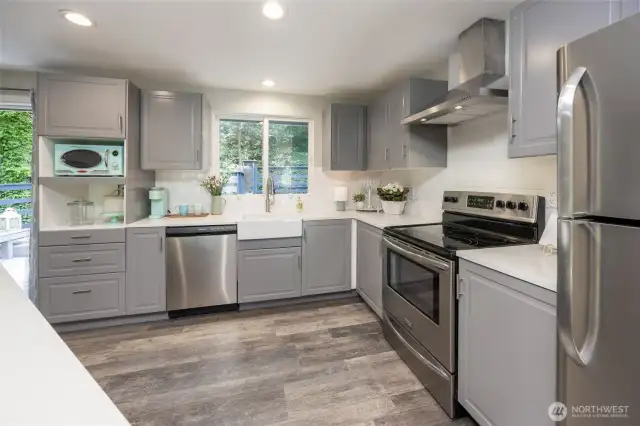 Beautifully remodeled kitchen features quartz countertops, SS appliances, custom cabinets & LVP floors.